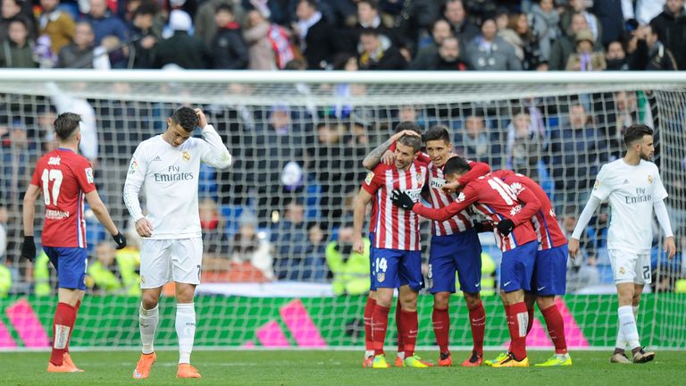 Cristiano Ronaldo of Real Madrid walks away from celebrating Atletico Madrid players after Atletico beat Real 1-0 in the La Liga