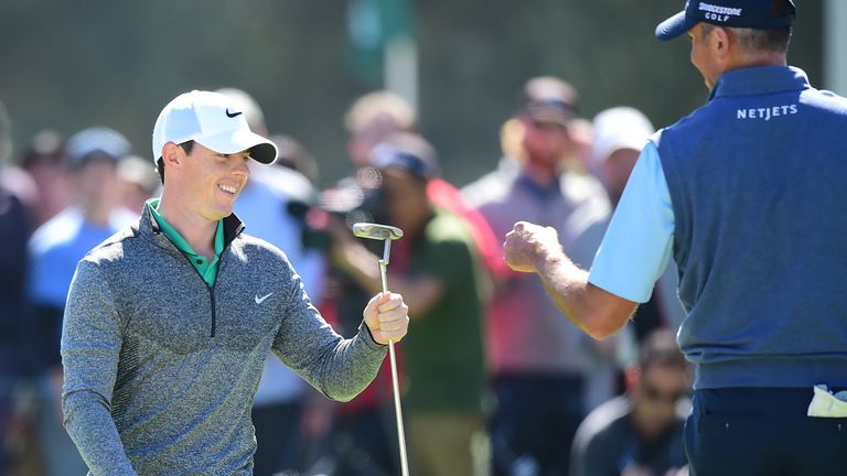 Rory McIlroy celebrates with Matt Kuchar after sinking a monster putt for birdie at the third