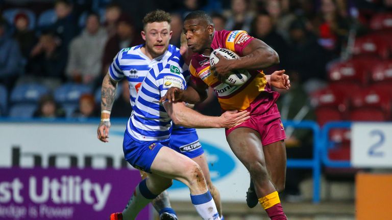 Huddersfield's Jermaine Mcillvary is tackled by Wigan's Liam Farrell