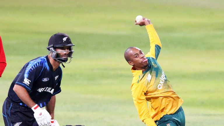 South Africa's Aaron Phangiso (R) bowls as New Zealand's Grant Elliott (L) watches during a T20I last August 