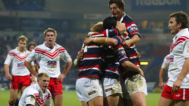 Craig Fitzgibbon of the Sydney Roosters celebrates as Darren Albert and John Stankevich of St Helens look on