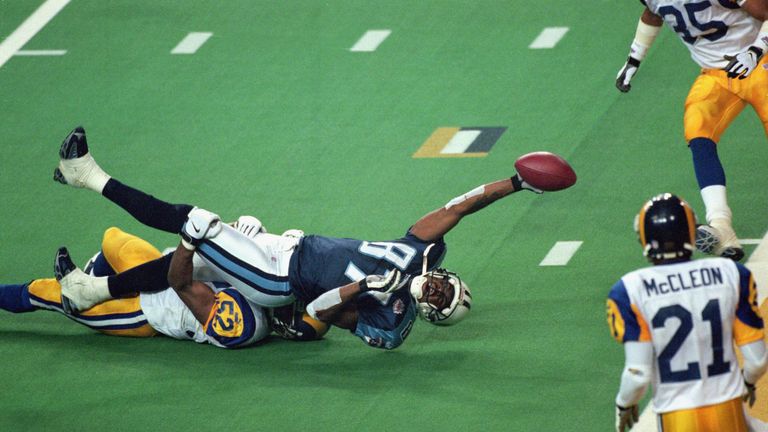 ATLANTA - JANUARY 30:  Kevin Dyson #87 of the Tennessee Titans reaches for the end zone with the ball as Mike Jones #52 of the St. Louis Rams tackles him o