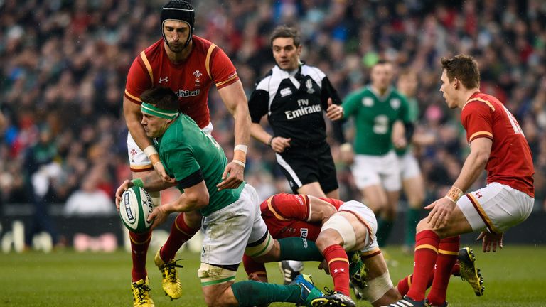 CJ Stander of Ireland is tackled by Luke Charteris and Sam Warburton of Wales