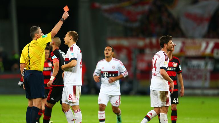 Referee Knut Kircher shows a red card to Xabi Alonso