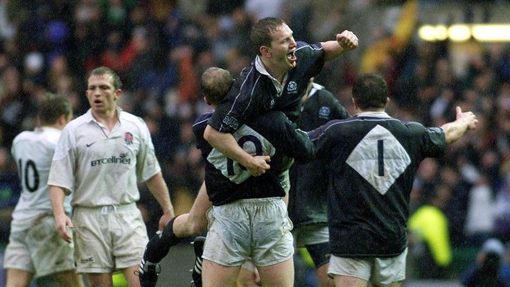 England's captain Matt Dawson (left) walks towards  Scotland captain Andy Nicol as he is lifted in the air by  Duncan Hodge with Tom Smith (right) 