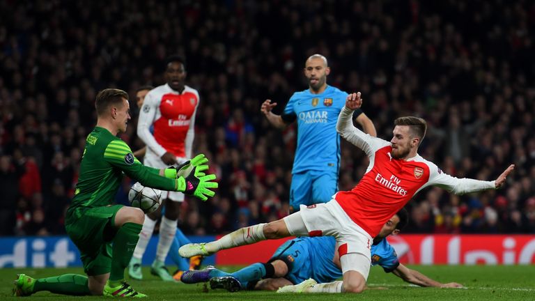 Aaron Ramsey of Arsenal competes for the ball with goalkeeper Marc-Andre ter Stegen and Sergio Busquets of Barcelona