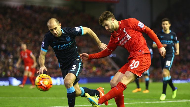 Adam Lallana of Liverpool crosses the ball under pressure from Pablo Zabaleta 