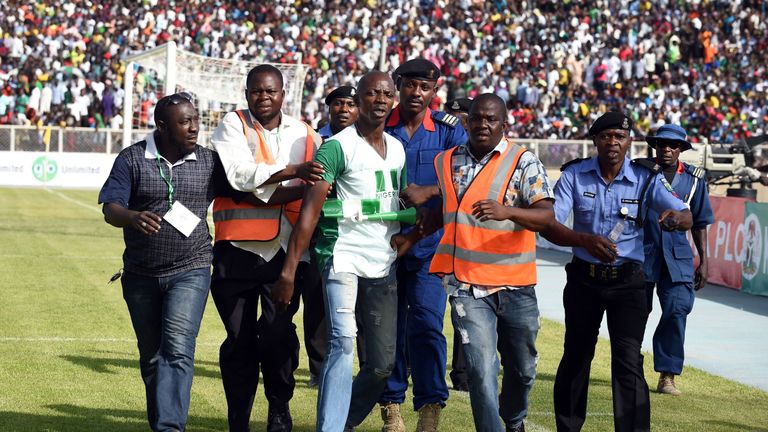 Security officials remove a man who tried to hug Nigerian players during the African Cup of Nations qualification match against Egypt 