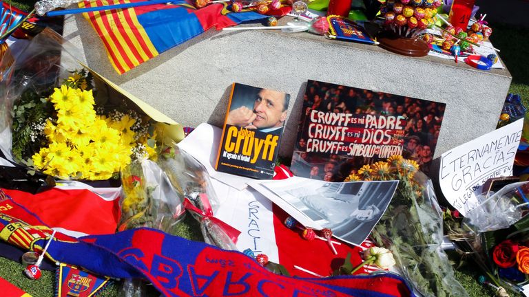 Flowers, scarves, flags, a book, lollipops and messages displayed by fans lay where they tribute to late Dutch football star Johan Cruyff