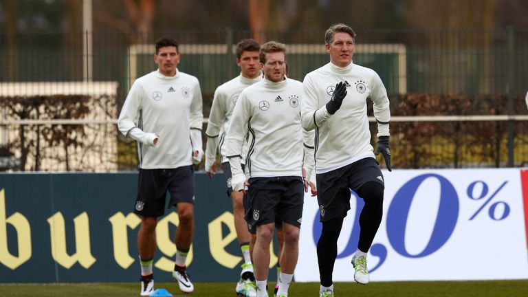 Bastian Schweinsteiger (R) of Germany and his team mates look on