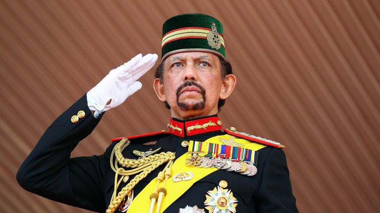 Brunei's Sultan Hassanal Bolkiah salutes during a ceremonial guard of honour to mark his 68th birthday celebrations in Bandar Seri Begawan on August 14, 20