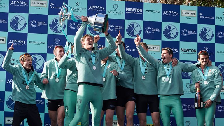 The Cambridge men's crew celebrate with trophy after winning the annual men's boat race between Oxford and Cambridge University