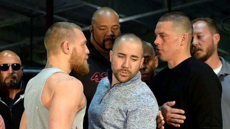 UFC featherweight champion Conor McGregor (L) and lightweight contender Nate Diaz (R) are held apart by Dave Sholler (C), UFC 