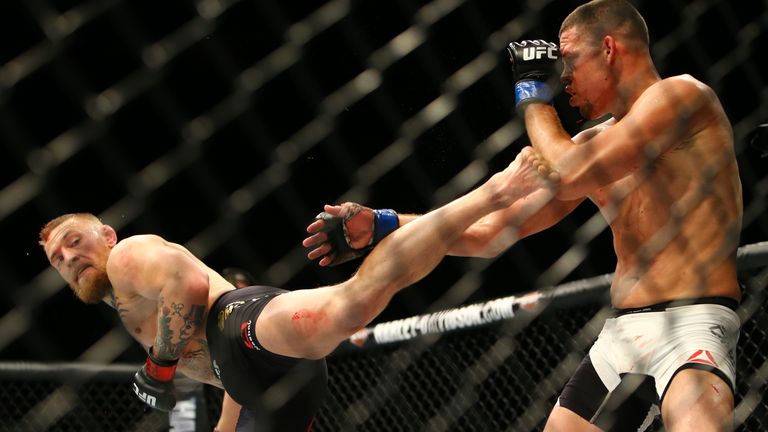 Conor McGregor (L) kicks Nate Diaz during UFC 196 at the MGM Grand Garden Arena on March 5, 2016 in Las Vegas, Nevada. (Photo b