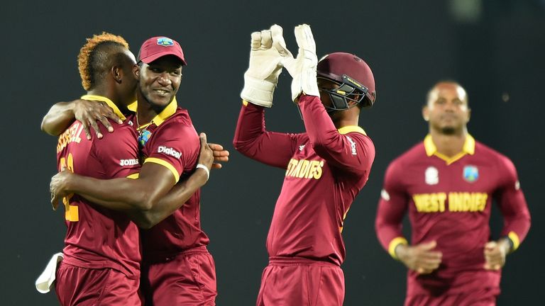 Darren Sammy (2L) celebrates with West Indies teammates Andre Russell (L) and Denesh Ramdin(2R)after the wicket of South Africa's batsman Hashim Amla 