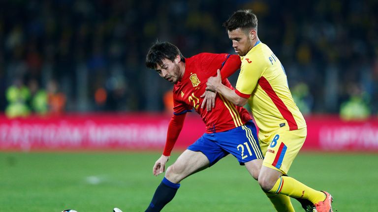 David Silva of Spain battles for the ball with Mihai Pintilii of Romania during the International Friendly match between Romania and Spain