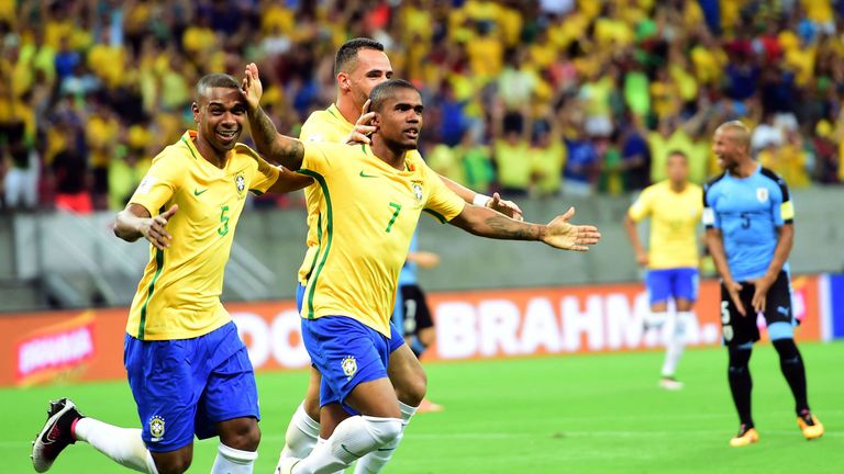 Brazil's Douglas Costa (R) celebrates after scoring against Uruguay