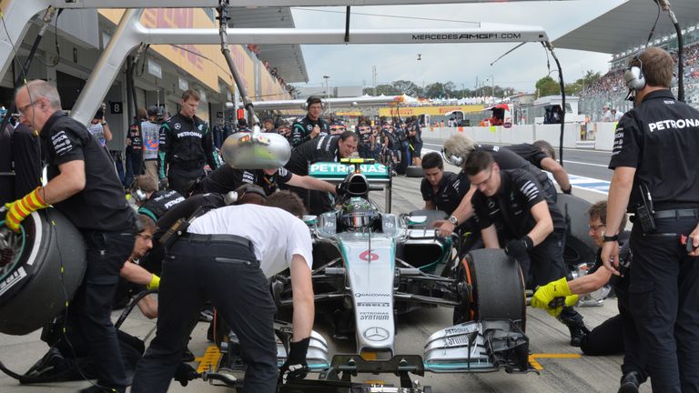 Mercedes pit crew perform a tyre change on the car of Nico Rosberg of Germany during the third practice session of the Formula One Japanese Grand Prix.