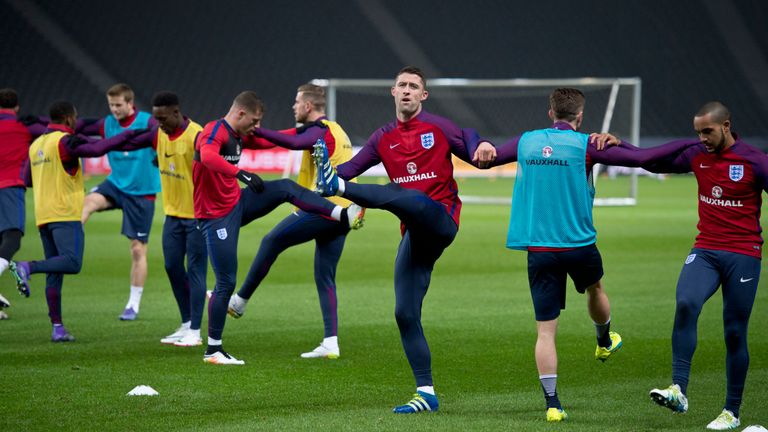 Gary Cahill (C) warms up with team mates during the England training session at Olympic Stadium on March 25, 2016 in Berlin, G