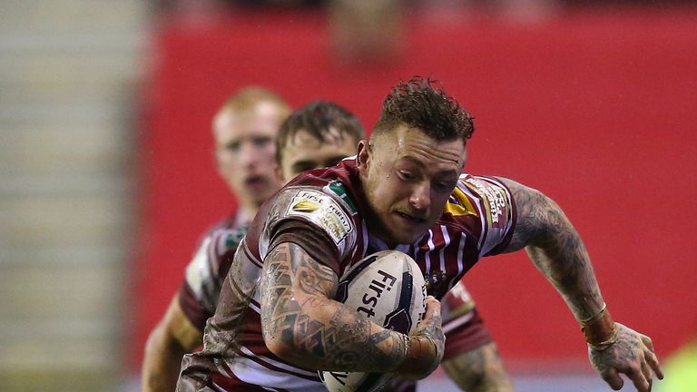 WIGAN, ENGLAND - FEBRUARY 05:  Josh Charnley of Wigan Warriors beats Julian Busquet of Catalans Dragons during the First Utility Super League match between