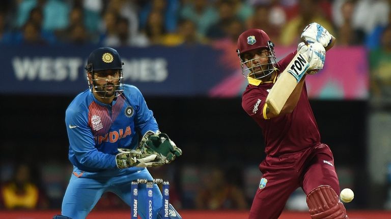 West Indies batsman Lendl Simmons(R)plays a shot as India's captain Mahendra Singh Dhoni looks on