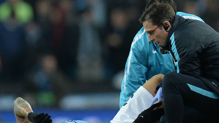 Manchester City defender Nicolas Otamendi (L) reacts as he receives medical treatment 