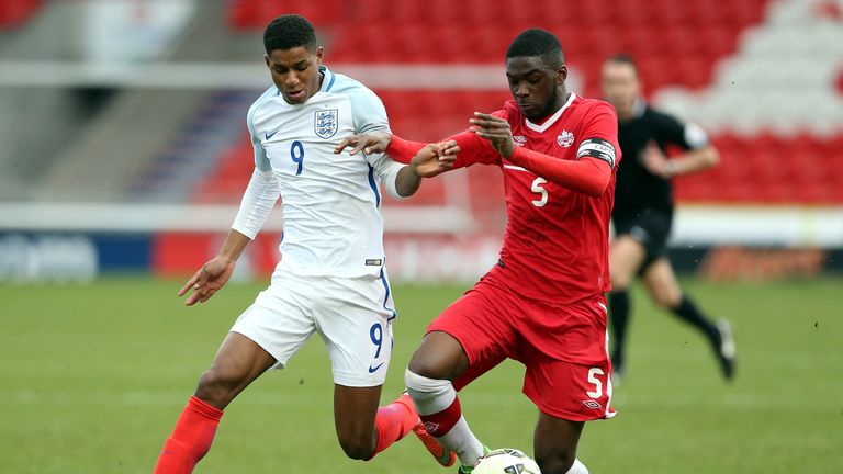 DONCASTER, ENGLAND - MARCH 27:  Marcus Rashford of England (L) challenged by Fikayo Tomori of Canada during 