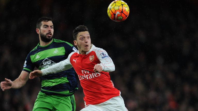 Mesut Ozil of Arsenal holds off Jordi Amat of Swansea