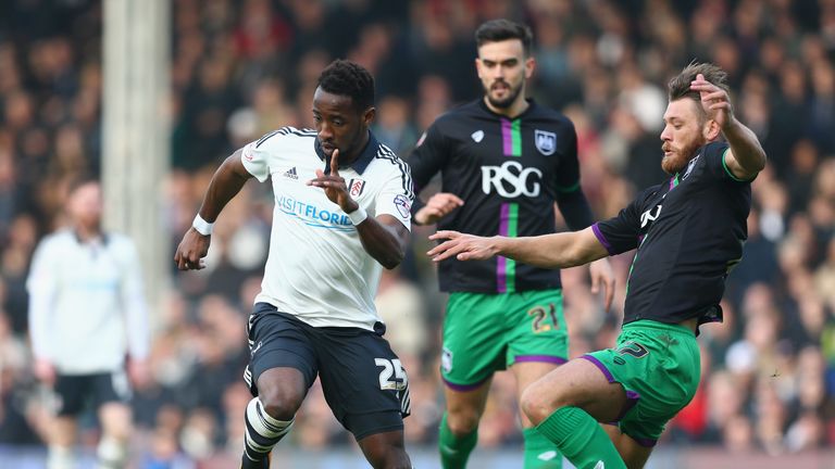 Moussa Dembele of Fulham (L) is tackled by Nathan Baker of Bristol City