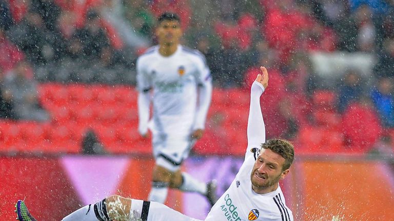 Valencia's German defender Shkodran Mustafi falls on the wet pitch during the UEFA Europa League Round of 16 first leg football ma