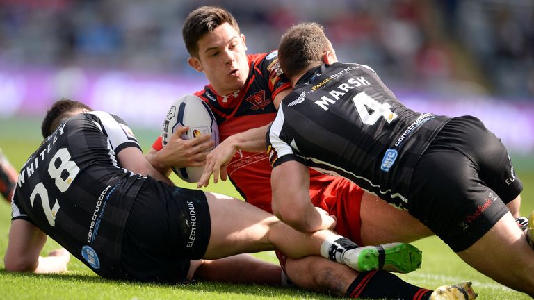 Niall Evalds (C) of Salford Red Devils challenged by Matt Whitley (L) and Stefan Marsh