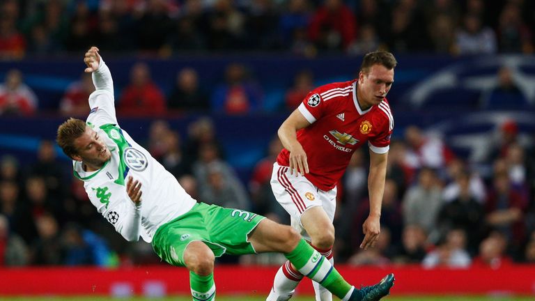 Phil Jones of Manchester United fends off Nicklas Bendtner of VfL Wolfsburg during the UEFA Champions League Group B match at Old Trafford
