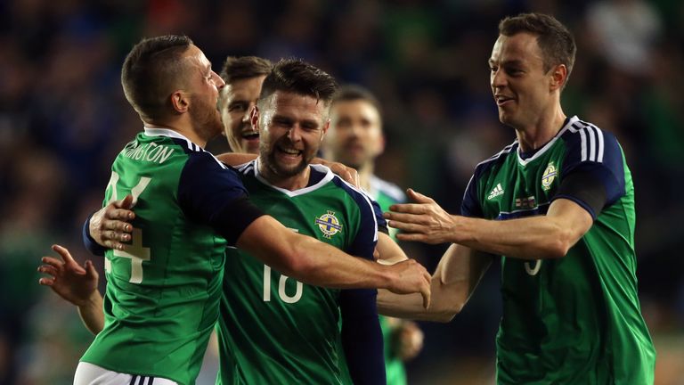 Northern Ireland's Conor Washington (left) celebrates scoring his side's first goal of the game with team mates Oliver Norwood and Jonathan Evans