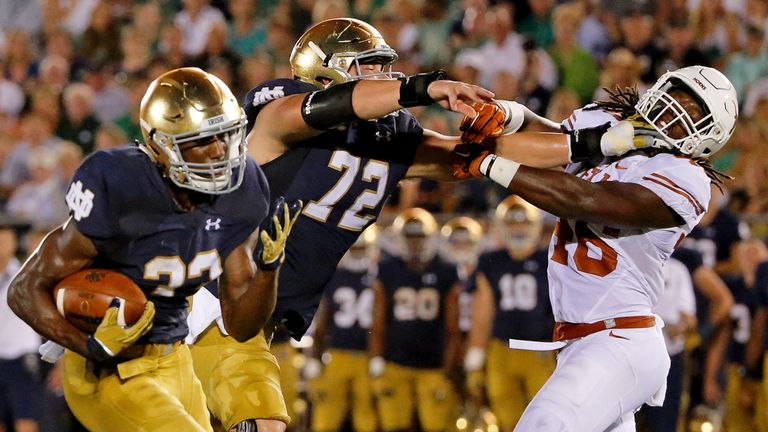 Nick Martin #72 of the Notre Dame Fighting Irish blocks Jermaine Roberts #16 of the Texas Longhorns as Josh Adams #33