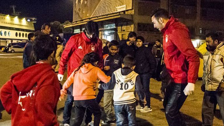 Olympiakos players play football with refugee children
