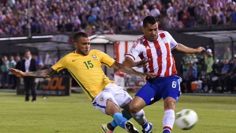 Paraguay's Miguel Samudio [right] tries to get his cross in under pressure from Dani Alves [left]
