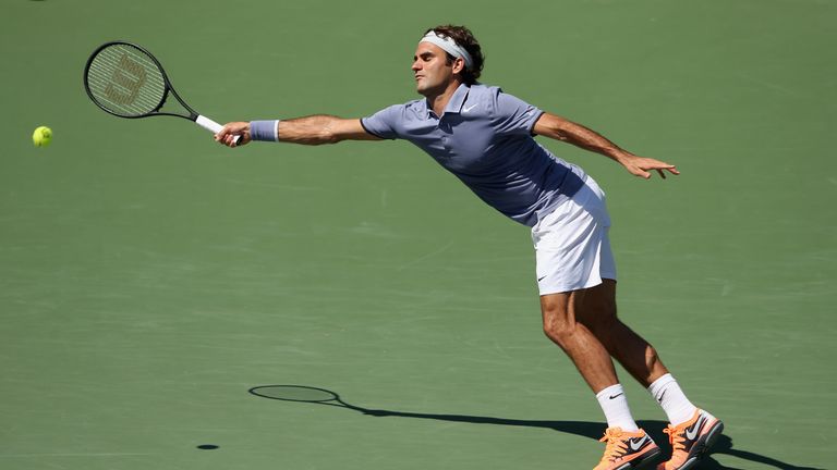 Roger Federer of Switzerland stretches to play a forehand against Ivo Karlovic of Croatia  during their second round match du