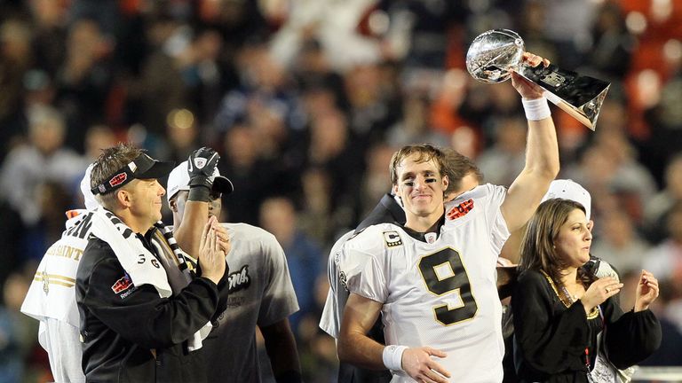 MIAMI GARDENS, FL - FEBRUARY 07: Drew Brees #9 of the New Orleans Saints holds up the Vince Lombardi Trophy as head coach Sean Payton looks on after defeat