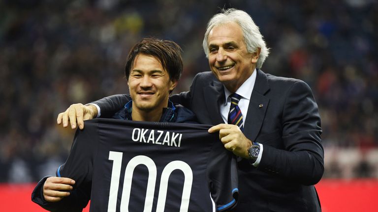 Shinji Okazaki poses for photographs with a shirt to mark his 100th appearance for Japan