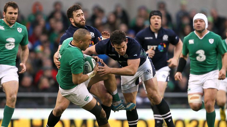 Ireland's Simon Zebo (second left) tackles Scotland's John Hardie