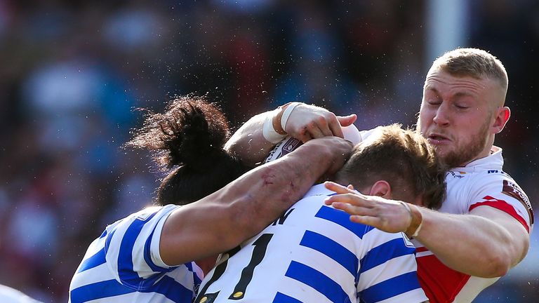 St Helens' Luke Thompson is tackled by Wigan's Taulima Tautai and Ryan Sutton.