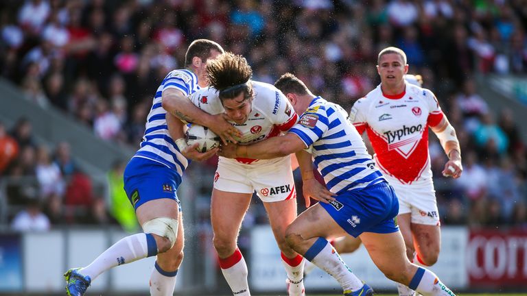 St Helens' Louie McCarthy-Scarsbrook is tackled by Wigan's Tony Clubb and Ben Flower.