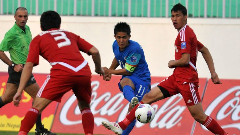 Tajikistan footballer Savankulov (L) and Indian attacker Sunil Chhetri (C) tussle for the ball during their AFC Challenge Cup 2012 football match in Kathma