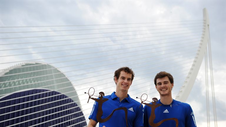 Andy Murray (left) and Jamie Murray pose with the doubles winners trophy in Valencia