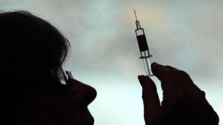 A person holding a syringe