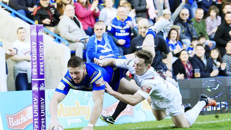 Warrington's Tom Lineham scores a try tackled by Widnes's Tom Gilmore