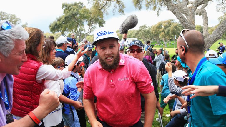 Andrew Johnston of England walks past spectators on the 18th green after his round during the final round on day four