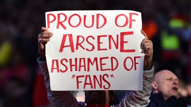 An Arsenal fan holds up a sign in a show of support for Arsene Wenger
