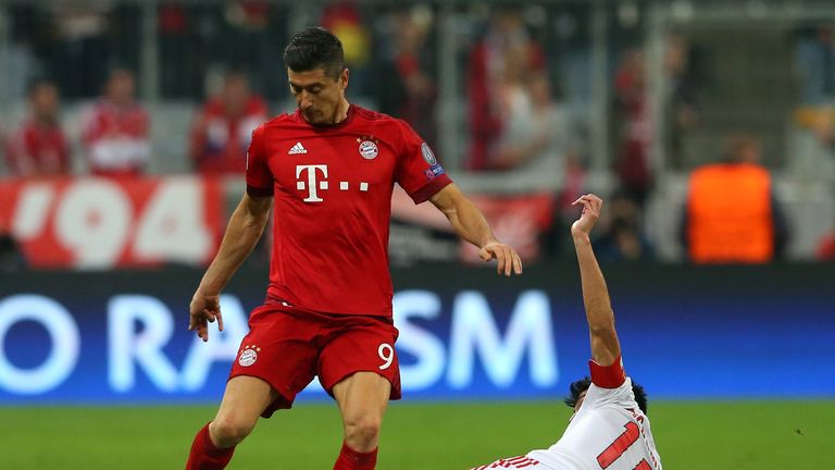  Robert Lewandowski of Bayern Munich is tackled by Nicolas Gaitan of Benfica during the U