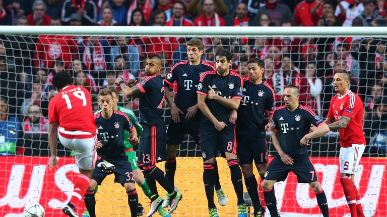 Bayern Munich players jump in the wall to defend a free kick